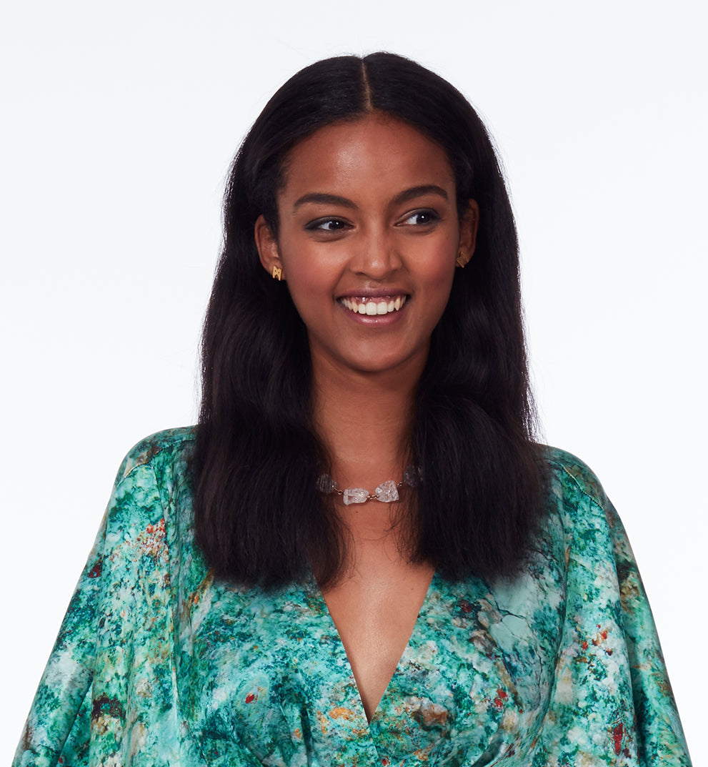 Model wearing the Not a Pearl Necklace Rough Quartz by Märta Larsson with a patterned outfit and joyful expression, styled with vibrant, expressive elegance.