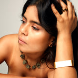 Model wearing the Not a Pearl Necklace Pyrite by Märta Larsson with a gold bracelet and zigzag ring, styled for confident radiant elegance.