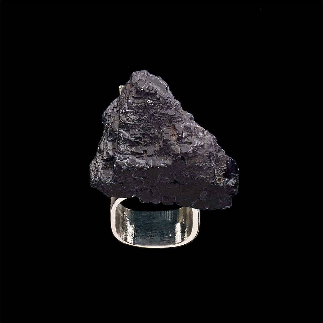 Close-up of a hand wearing the Roxx Black Tourmaline Asymmetrical Ring by Märta Larsson. The large raw stone and sculptural gold band make this a standout black tourmaline ring for modern styling.