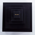 Roxx Pyrite Double Cube Ring by Märta Larsson placed in concentric black boxes with gold branding. Elegant packaging for handcrafted gemstone rings and luxury accessories.