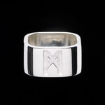 Signature Silver Ring by Märta Larsson in polished 925 sterling silver, displayed against a black background. This minimalist designer ring features a bold 10mm band with engraved logo — a sculptural silver ring for men and women, perfect for modern styling and handcrafted Swedish jewelry.
