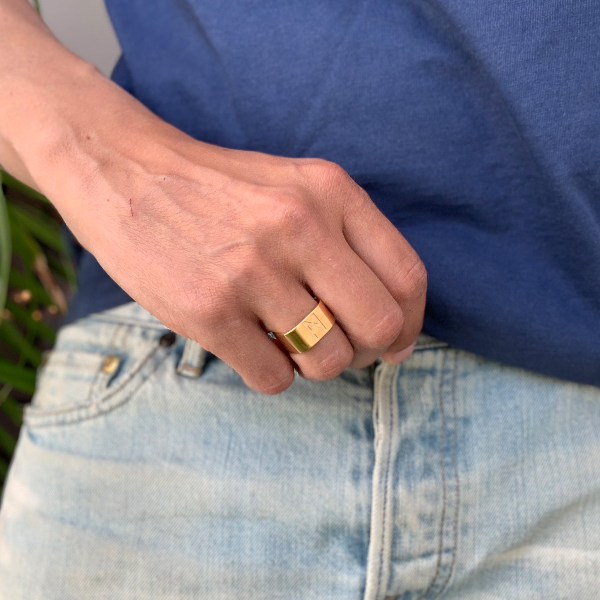 Close-up of a male hand wearing the Signature Gold Vermeil Ring by Märta Larsson on the ring finger, a minimalist unisex gold-vermeil statement band