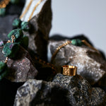 Signature Gold Vermeil Ring by Märta Larsson placed on natural stones, a sculptural gold-vermeil band echoing raw beauty in Swedish design.