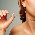 Close-up of The Raw One Black Tourmaline Necklace by Märta Larsson with a cube-shaped raw tourmaline pendant on a gold-vermeil chain, styled for minimalist everyday edge.