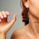Close-up of The Raw One Black Tourmaline Necklace by Märta Larsson with a cube-shaped raw tourmaline pendant on a gold-vermeil chain, styled for minimalist everyday edge.
