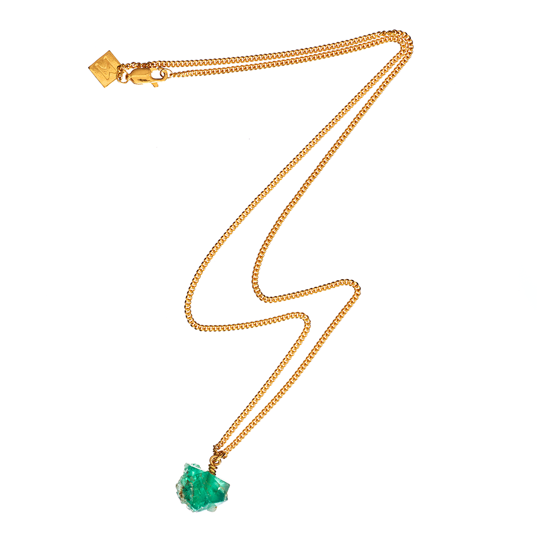 The Raw One Necklace by Märta Larsson featuring a gold chain and raw green fluorite stone, displayed on a white background.