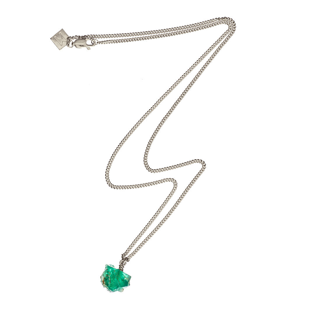 The Raw One Necklace by Märta Larsson featuring a silver chain and raw green fluorite stone, displayed on a white background.