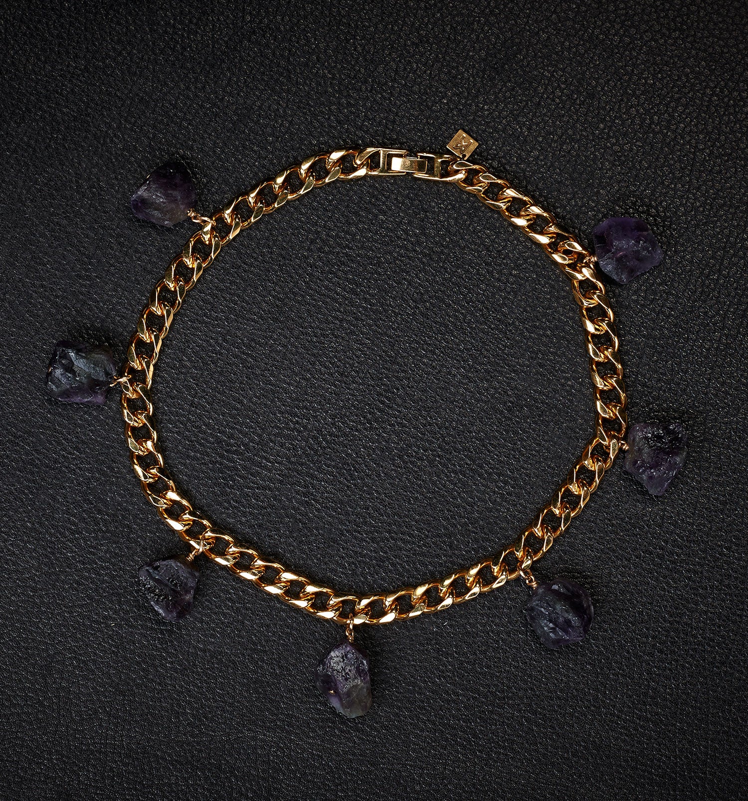  Collar Amethyst Bracelet by Märta Larsson laid out on black textured surface. Gold bracelet with raw amethyst charms — elegant, expressive, and naturally powerful.
