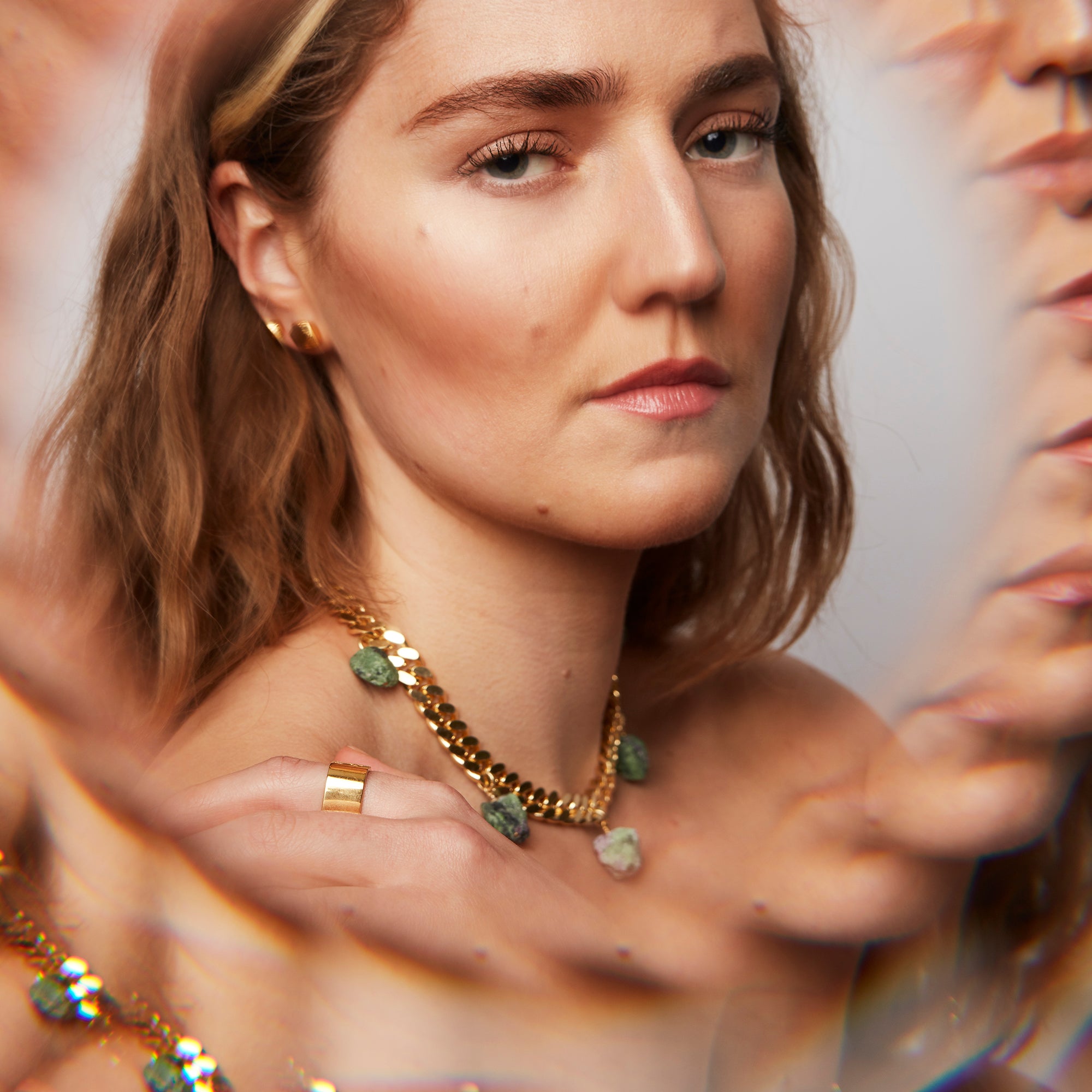 Model wearing the Collar Ruby Zoisite Necklace by Märta Larsson with kaleidoscopic reflections, a raw gemstone piece styled for expressive elegance.