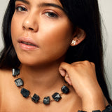 Model wearing the Not a Pearl Necklace Black Tourmaline by Märta Larsson with a matching bracelet and gold earring, styled for confident natural elegance.
