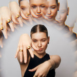 Model holding both hands forward wearing The Power Ring by Märta Larsson in gold vermeil on the index finger, featuring a bold raw crystal for striking artistic style.