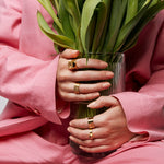 Model holding a vase with both hands while wearing the bold, raw and sophisticated Märta Larsson Power Ring, a gold-vermeil statement piece with raw crystal detail on the index finger