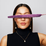Model in a black sleeveless top wearing The Raw One Dalmatian Necklace by Märta Larsson, a spotted stone pendant styled with gold earrings.