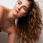 Model wearing the Rolling Stone Necklace by Märta Larsson with a black strapless top, a raw stone silver piece styled for modern elegance and everyday edge.