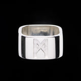 Signature Silver Ring by Märta Larsson in polished 925 sterling silver with bold 10 mm engraved band, displayed against a black background.