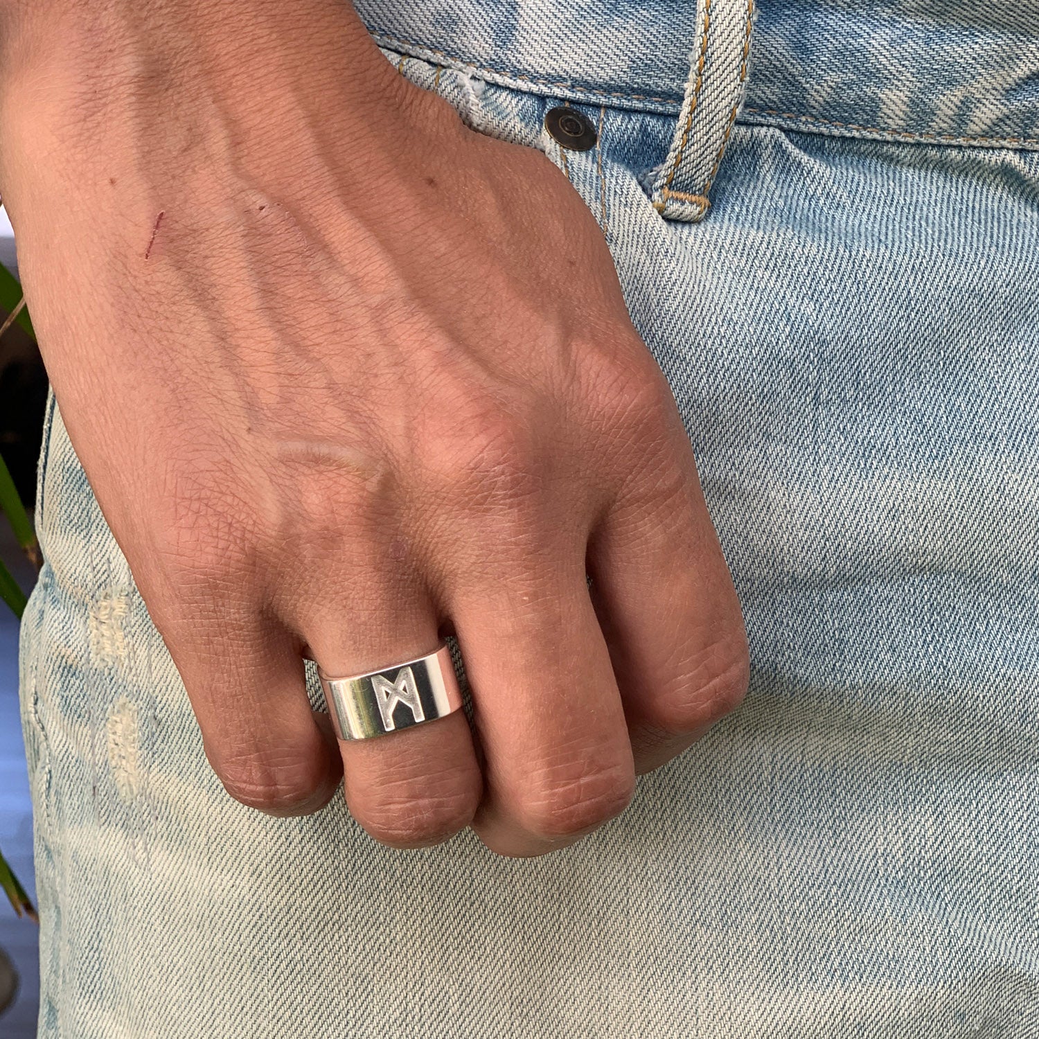Close-up of a male hand wearing the Signature Silver Ring by Märta Larsson on the ring finger, featuring a polished finish and bold sculptural silver band.