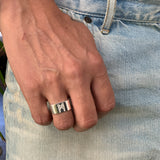 Close-up of a male hand wearing the Signature Silver Ring by Märta Larsson on the ring finger, featuring a polished finish and bold sculptural silver band.