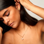 Model wearing The Raw One Rough Quartz Necklace by Märta Larsson, a raw clear quartz pendant on gold chain styled for modern simplicity.