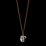 The Raw One Rough Quartz Necklace by Märta Larsson on black background, a gold-vermeil chain with raw clear quartz for bold frozen-light contrast.
